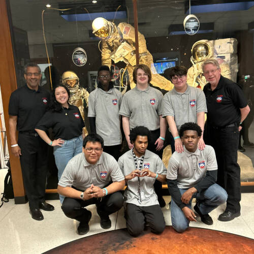 group of students in front of museum astronaut